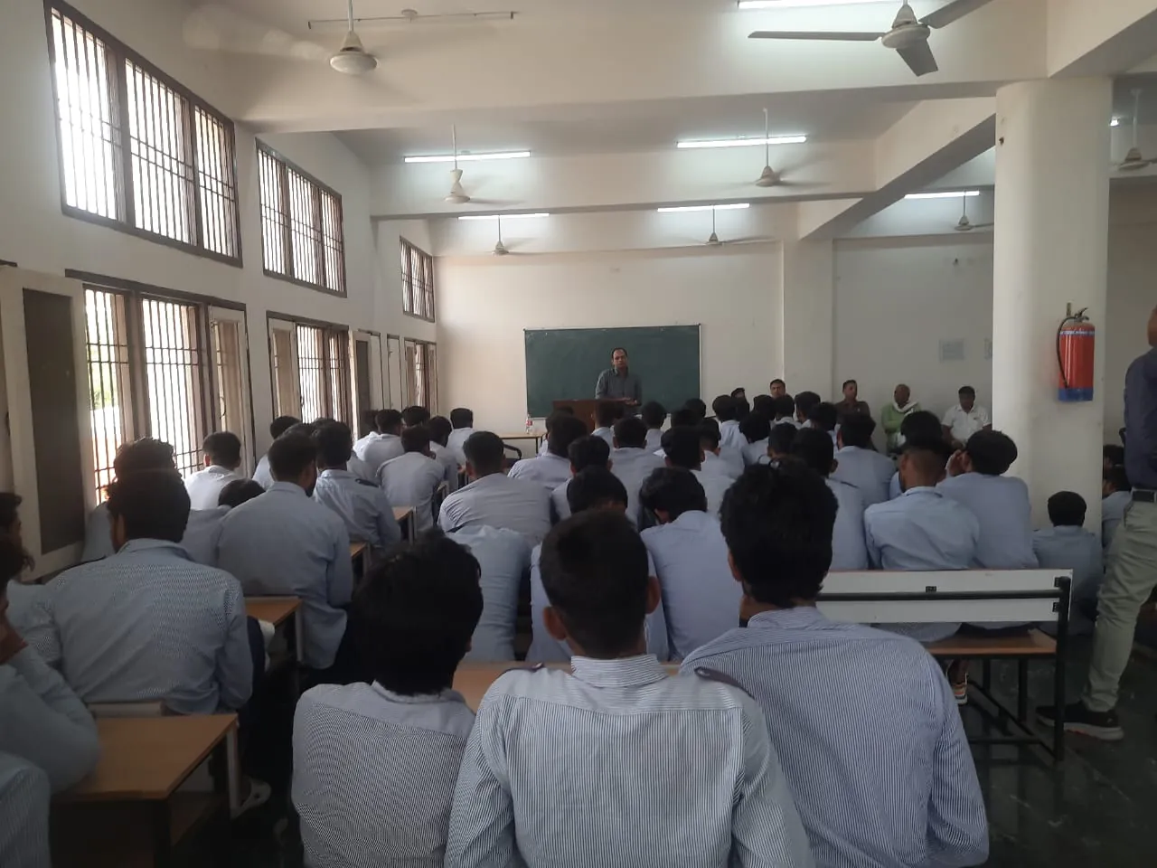 Manjeet Yadav speaking to a full classroom of college students