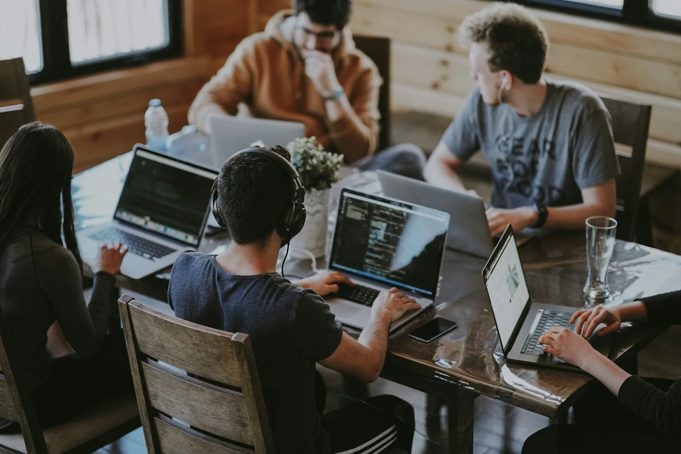 A small team reviewing work together on laptops